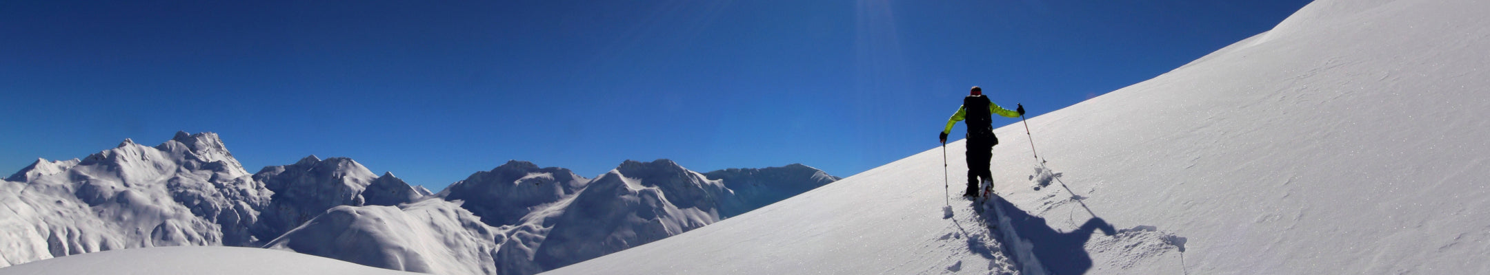 Tourengeher im Tiefschnee, blauer Himmel, strahlender Sonnenschein